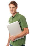 Smiling young man holding laptop
