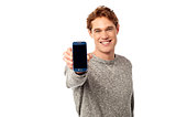 Young man displaying brand new cellphone