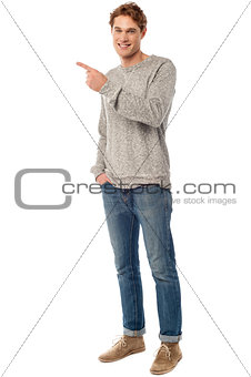 Casual young man pointing away