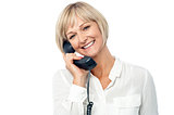 Smiling woman holding phone receiver