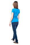 Back view of walking casual woman