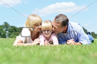 Parents kissing their sweet angel