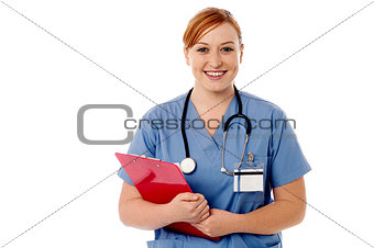 Young female nurse holding clipboard