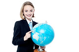 Business girl indicating a place in globe map
