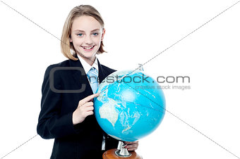 Business girl indicating a place in globe map