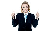 Smiling girl gesturing double thumbs up