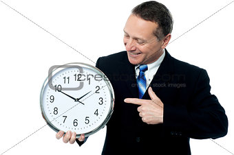 Smiling man holding a clock in his hands