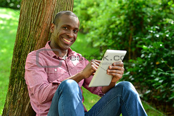 Handsome man with tablet in the park
