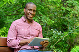 Happy guy using his tablet pc, outdoors