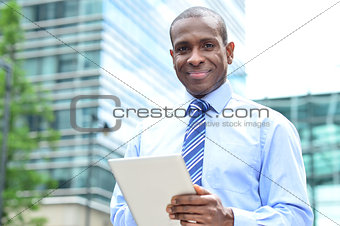 Smiling man using tablet pc at outdoors