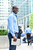 Smiling man standing outside offices building