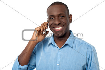 Happy african guy attending a phone call