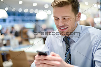 Happy young executive using smart phone