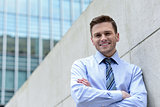 Smiling businessman standing against wall