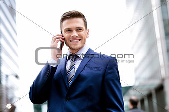 Smiling man in suit talking on cell phone