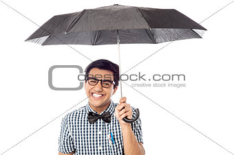 Smiling young man with an umbrella