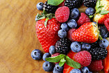 berry assortment - raspberries, blackberries, strawberries, blueberry on a wooden background