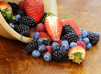 berry assortment - raspberries, blackberries, strawberries, blueberry on a wooden background