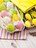 Easter with yellow tulips, colorful eggs and gift bag