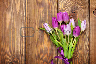Purple tulips over wooden table