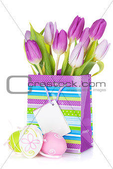 Purple tulip bouquet in gift bag and easter eggs