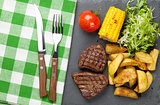 Steak with grilled potato, corn and salad