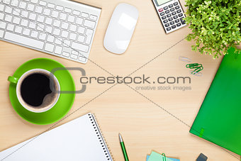 Office table with coffee cup, computer and flower