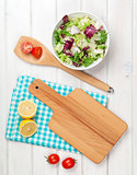 Fresh healthy salad over white wooden table