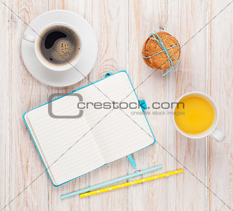 Cup of orange juice, coffee cup, gingerbread cookies and notepad