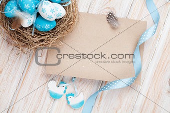 Easter greeting card with blue and white eggs in nest and decor 