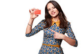 Beautiful woman in colorfull dress holding empty credit card and pointing at it,  isolated on white background