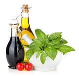 Olive oil and vinegar bottles with basil and tomatoes