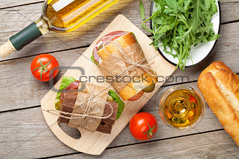 Sandwiches and white wine on wooden table