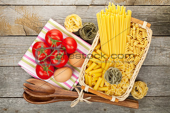 Various pasta, tomatoes and kitchen utensils