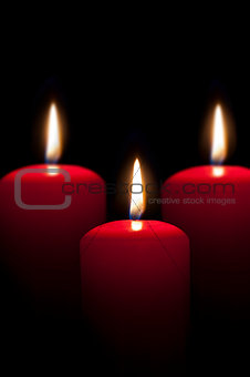 red candles lighting in the darkness