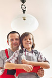 Son helping father changing a lightbulb