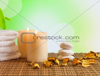 Spa massage border background with towel stacked, candles and perfumed leaves