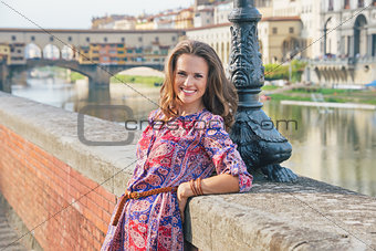 Portrait of happy young woman on embankment near ponte vecchio i