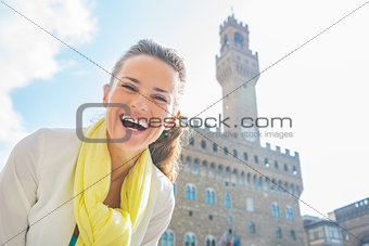 Happy young woman in front of palazzo vecchio in florence, italy