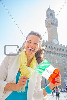 Happy young woman showing flag in front of palazzo vecchio in fl