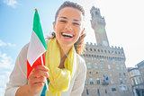 Happy young woman with flag in front of palazzo vecchio in flore