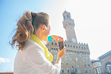 Young woman taking photo of palazzo vecchio in florence, italy. 