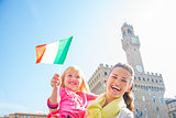 Portrait of happy mother and baby girl with flag in front of pal