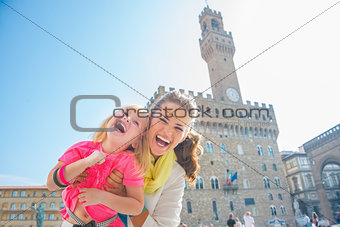 Portrait of happy mother and baby girl in front of palazzo vecch