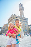 Portrait of smiling mother and baby girl in front of palazzo vec