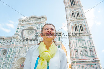 Happy young woman looking into distance in front of duomo in flo