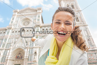 Happy young woman pointing on duomo in florence, italy