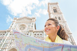 Happy young woman with map in front of duomo in florence, italy