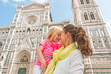 Happy mother and baby girl hugging in front of duomo in florence