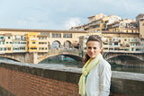 Young woman on embankment near ponte vecchio in florence, italy